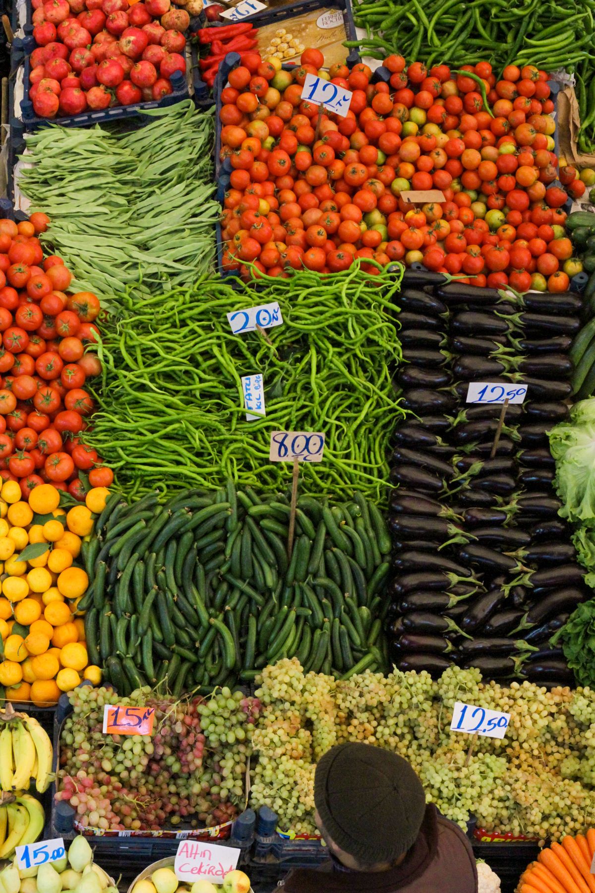A market stall piled with colorful fresh vegetables and fruit.