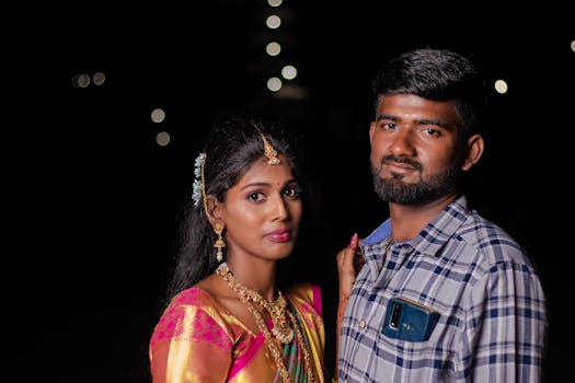 Beautiful Indian couple posing at night in traditional wedding attire.