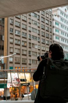 A photographer capturing a cityscape view with tall buildings in the background.