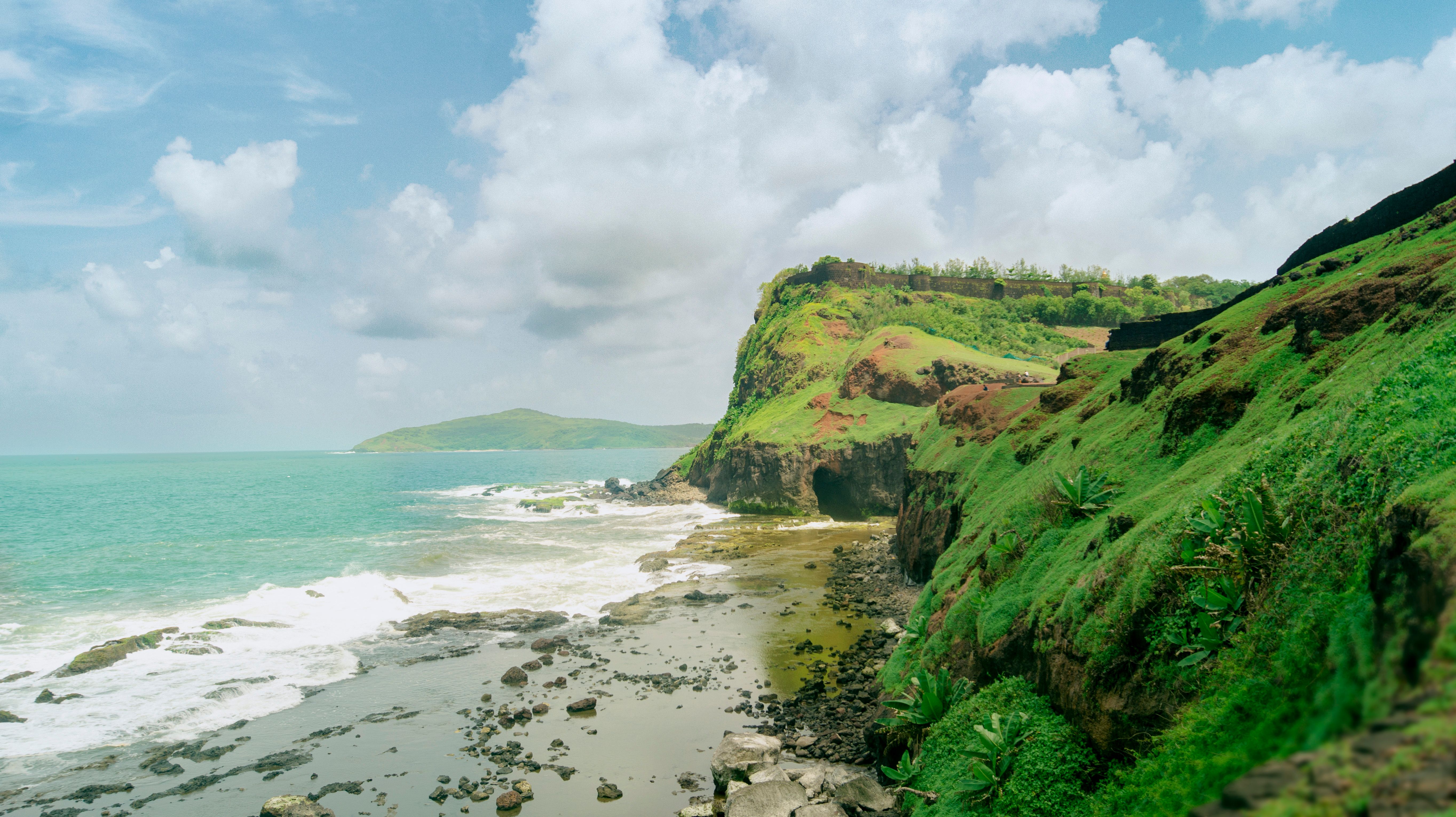 Explore the lush green cliffs and beautiful coastline of Ratnagiri, India in this stunning summer landscape.