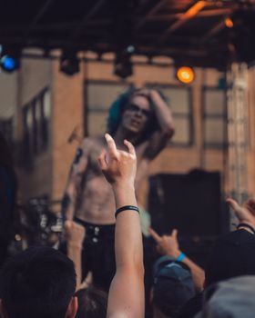 Band performing live at an outdoor festival with a crowd enjoying the music and raising hands.