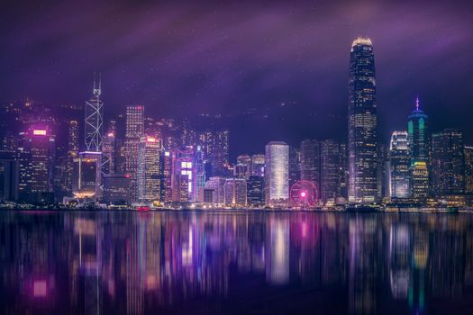 Beautiful night view of Hong Kong skyline with city lights reflecting on water.