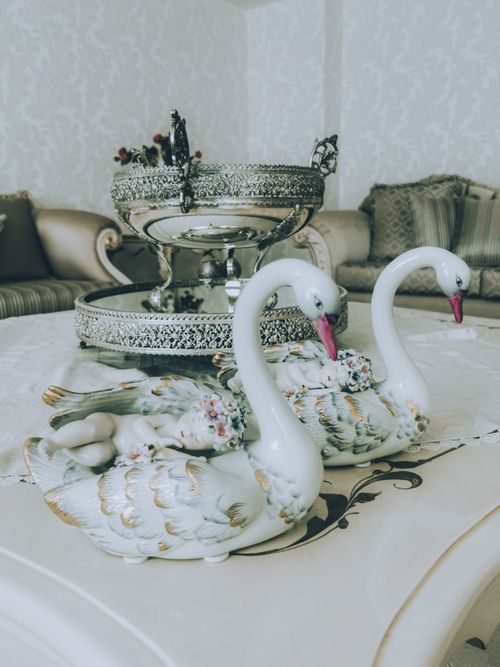 Free Close-up of ceramic swan figurines on a decorative table in a vintage-style room. Stock Photo