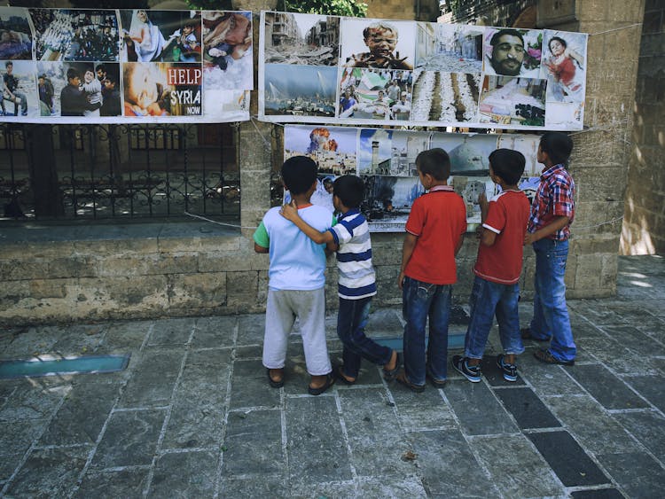 Kids Looking At The Hanging Banners On The Gate