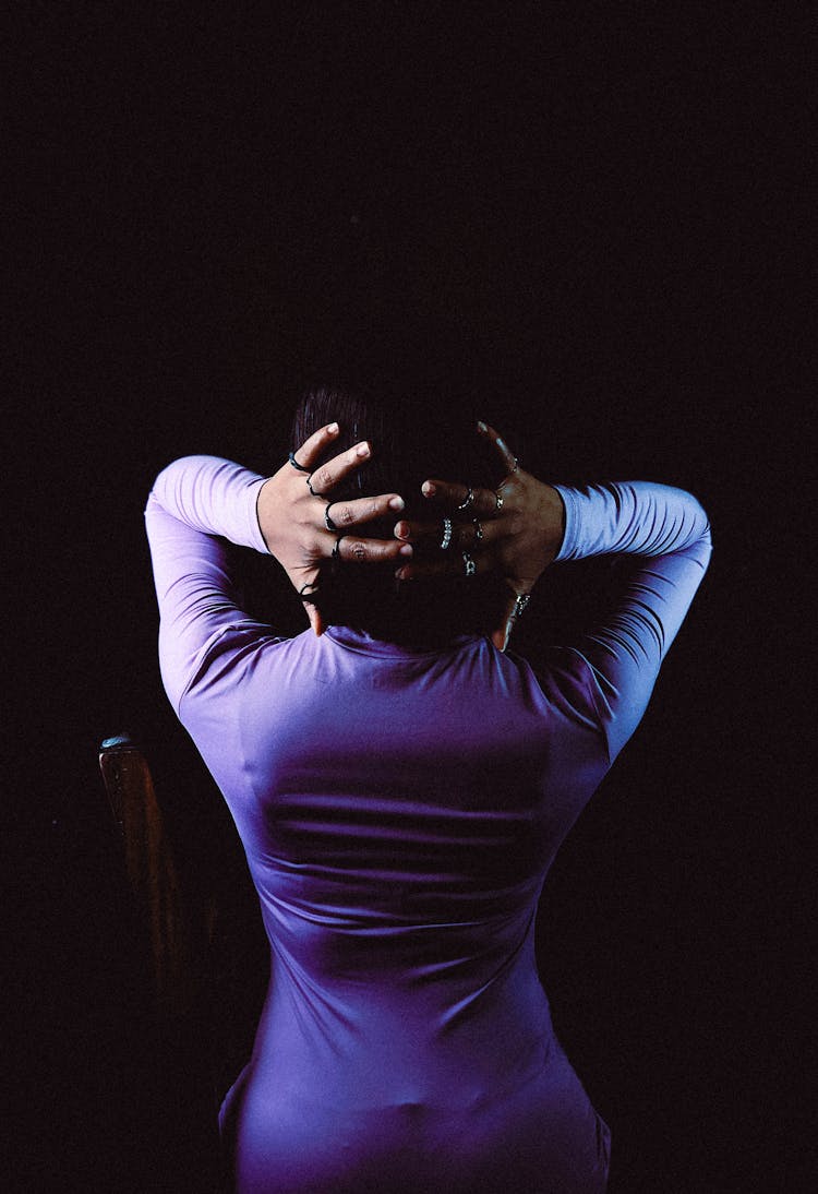 Back View Of A Woman Holding Hands In Hair