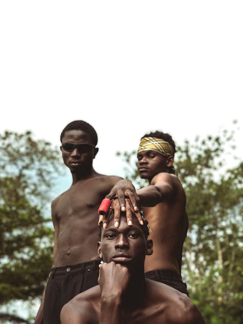 Shirtless Men Holding Hands on Friend Head