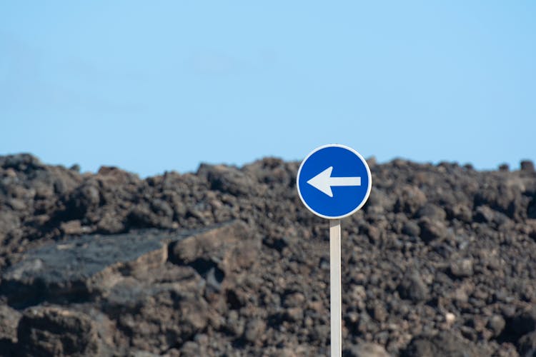 A One Way Sign Near A Natural Rock Formation