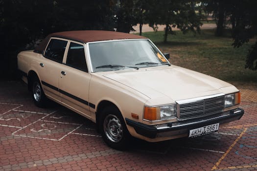 Classic vintage car with beige exterior parked on a brick paved area in Minsk.