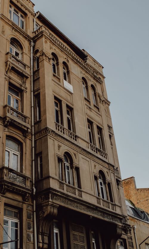 Free Detailed view of a neoclassical building facade with ornate elements in an urban cityscape. Stock Photo