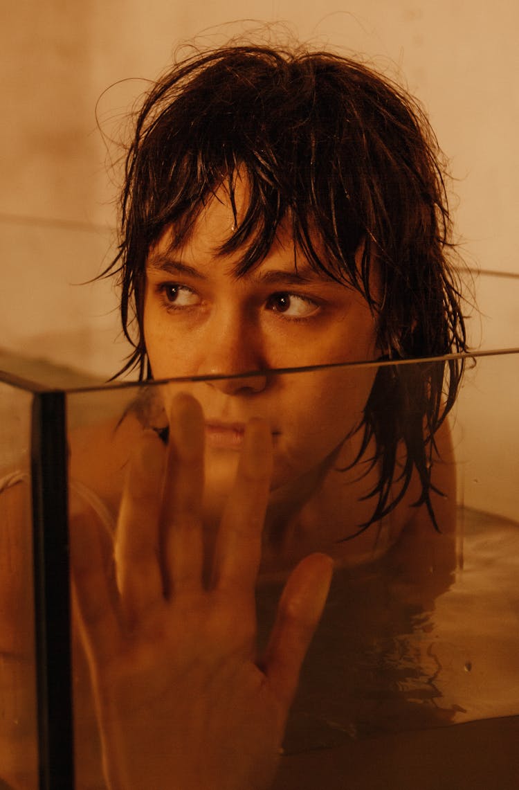 Portrait Of A Young Woman In A Glass Bathtub Filled With Water