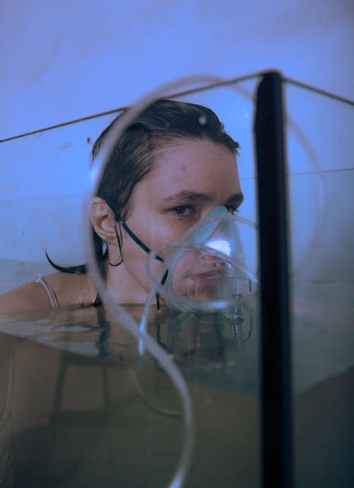 Woman Immersing in Water with a Inhalator on Face