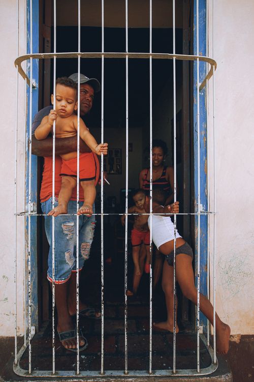 Free A family enjoying the outdoors on a sunny balcony with bars, creating a cozy atmosphere. Stock Photo