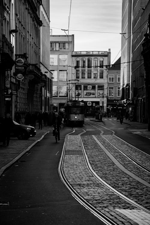 Black and White Photo of a Tram Riding in a Street