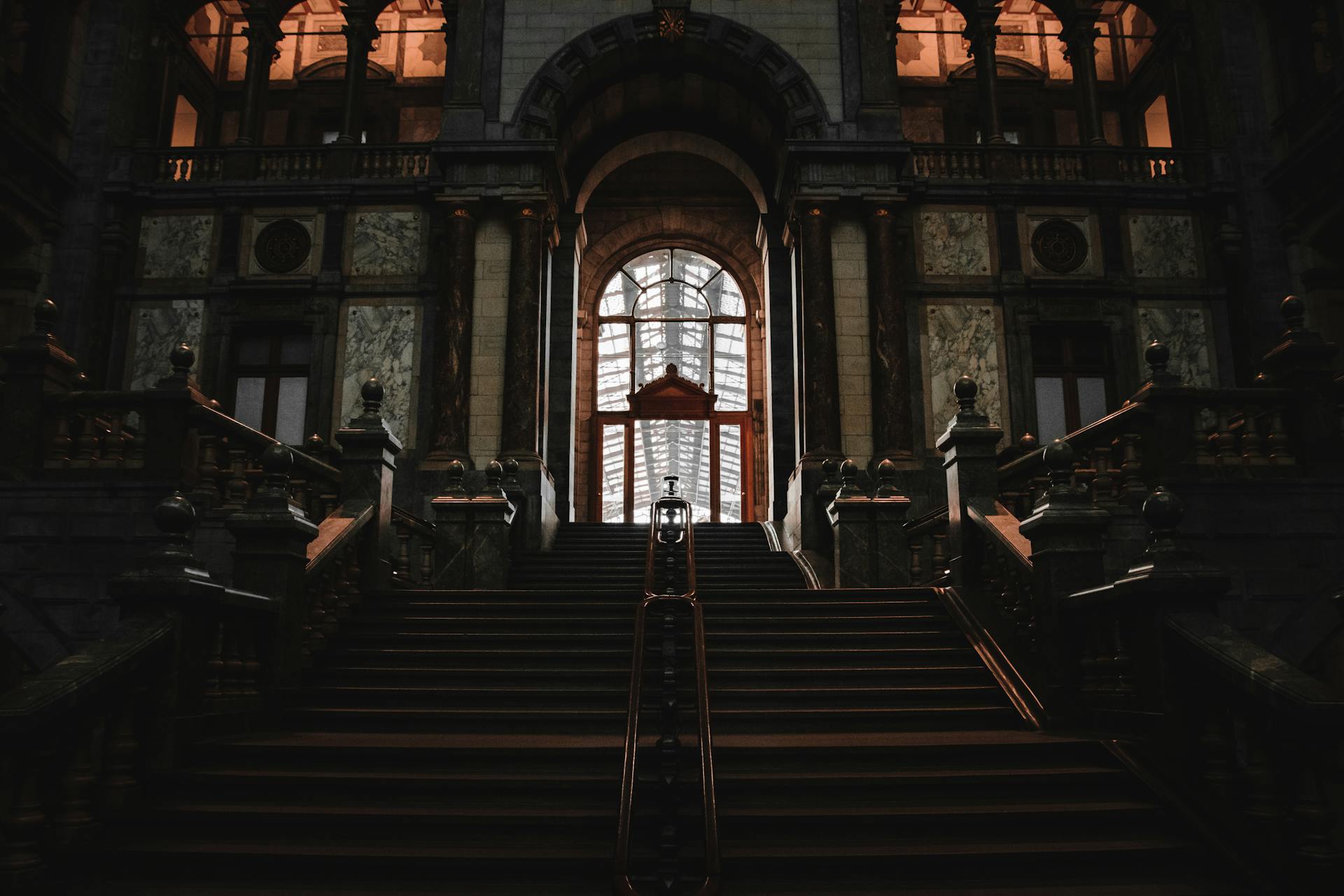 A grand staircase in a historic building showcasing intricate design and architecture.