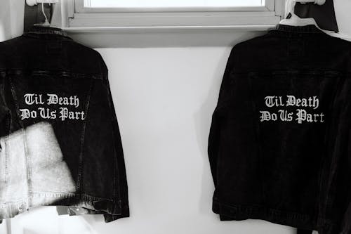 Black and White Jackets Hanging beside White Wall