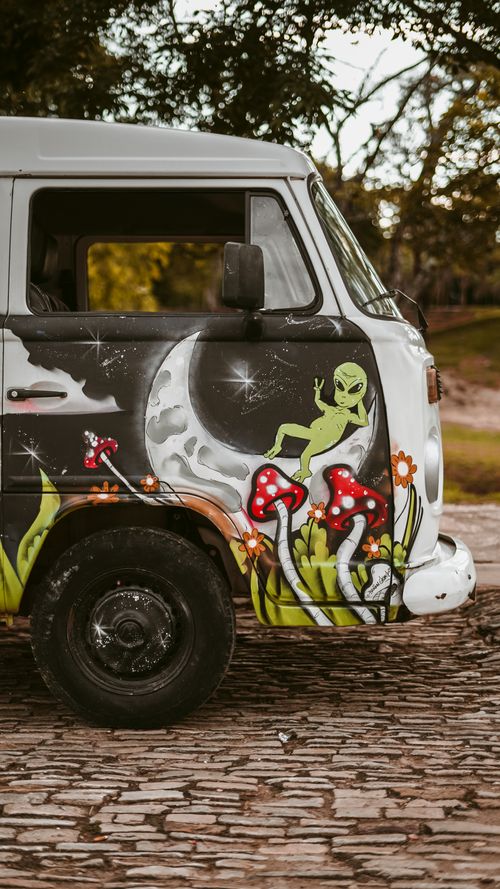 Free A vibrant image of a van with unique artwork featuring an alien, moon, and mushrooms. Stock Photo