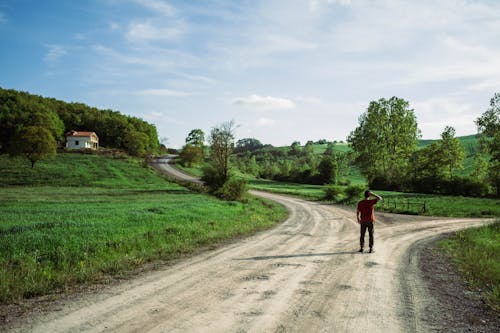 A Man Standing on Dirt Road
