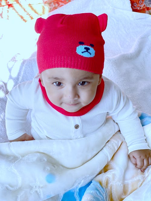 A Child in White Long Sleeves and Red Beanie