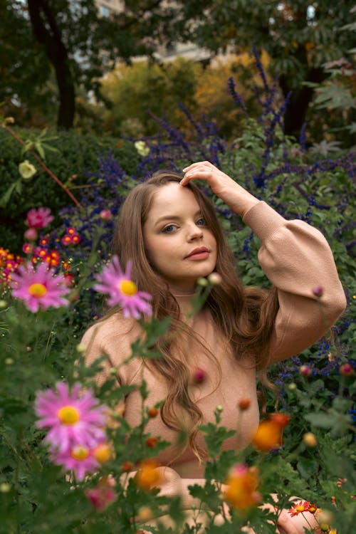 A Woman Posing Beside the Blooming Flowers
