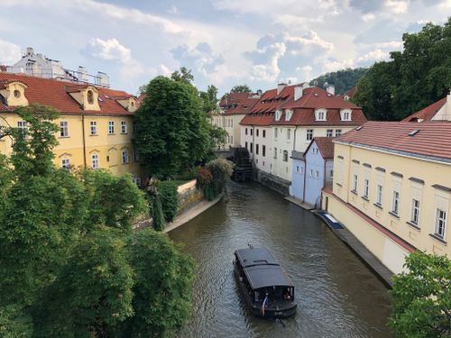 Free Charming buildings and a canal in Prague with a boat on a sunny day. Stock Photo