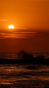 A stunning sunset over the ocean with warm orange tones and gentle waves.