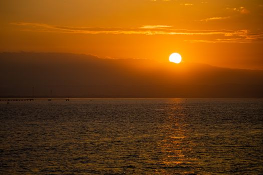 Stunning golden sunset over a serene sea horizon, capturing tranquil evening tones.