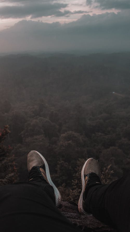 Person Sitting on the Edge of Mountain