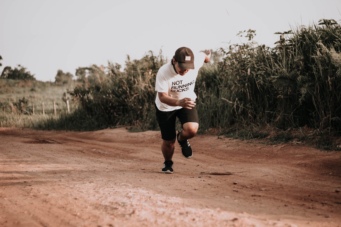 Free Man Running on Dirt Road Stock Photo