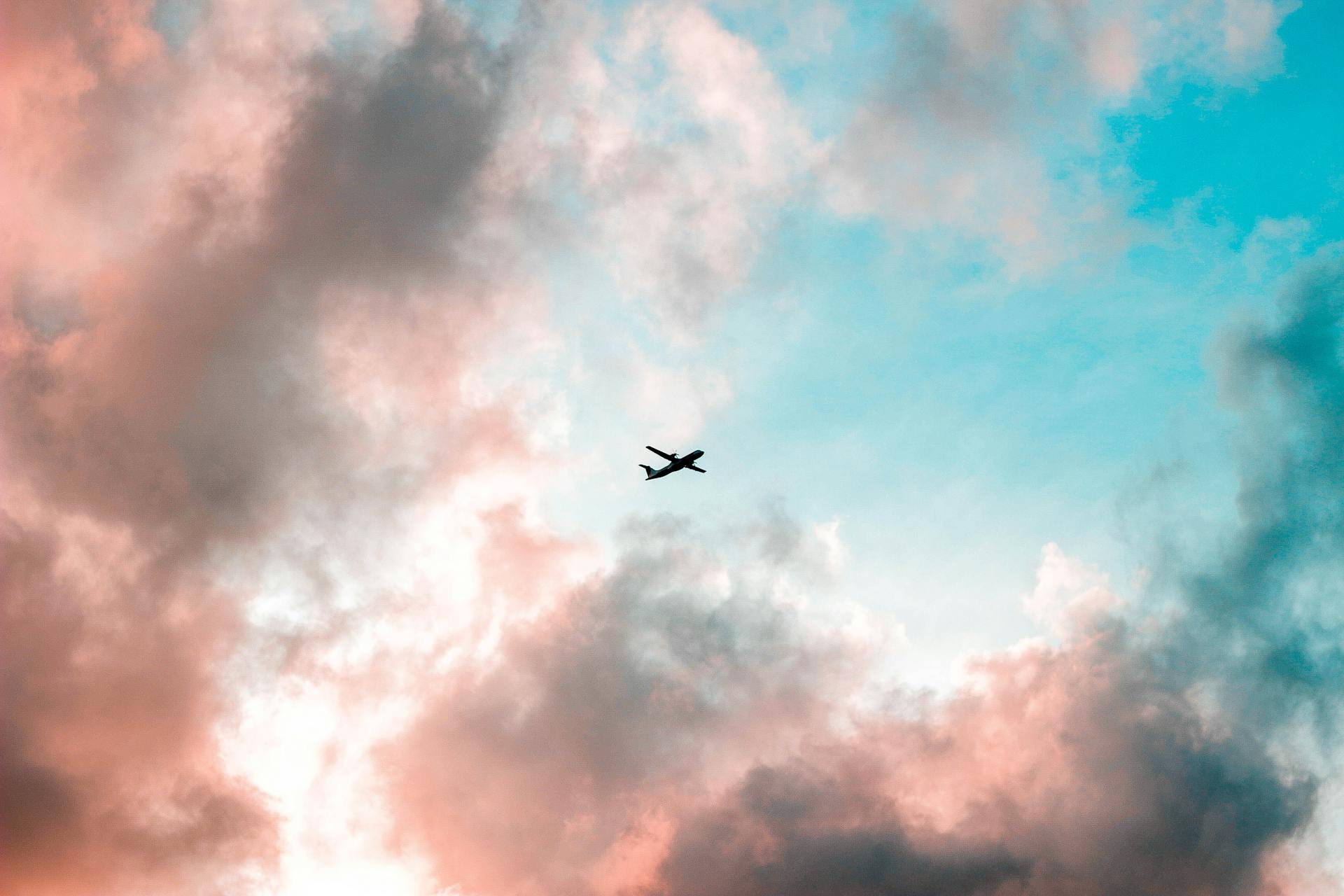 Silhouette of Airplane Under Cloudy Sky