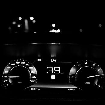 Captivating black and white image of a car dashboard with speedometer at night, showing 39 km/h.