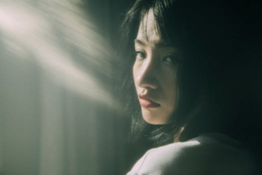 Portrait of a thoughtful young woman in soft sunlight, creating a dreamy and contemplative mood.