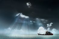 在马来西亚乔治城的穆迪海景，一艘渔船在戏剧性的云层和阳光照射下