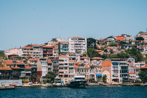 Free Charming Istanbul waterfront with colorful hillside buildings under a clear blue sky. Stock Photo