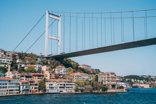 Free View of the Bosporus Bridge spanning over Istanbul skyline with clear blue sky. Stock Photo
