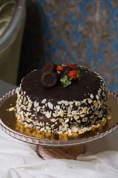 Mouthwatering chocolate almond cake topped with strawberries and wafers, perfect for dessert lovers.