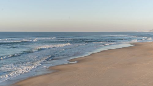 Free Gentle waves hitting the shore at Nazaré, Portugal, creating a calm seaside landscape. Stock Photo