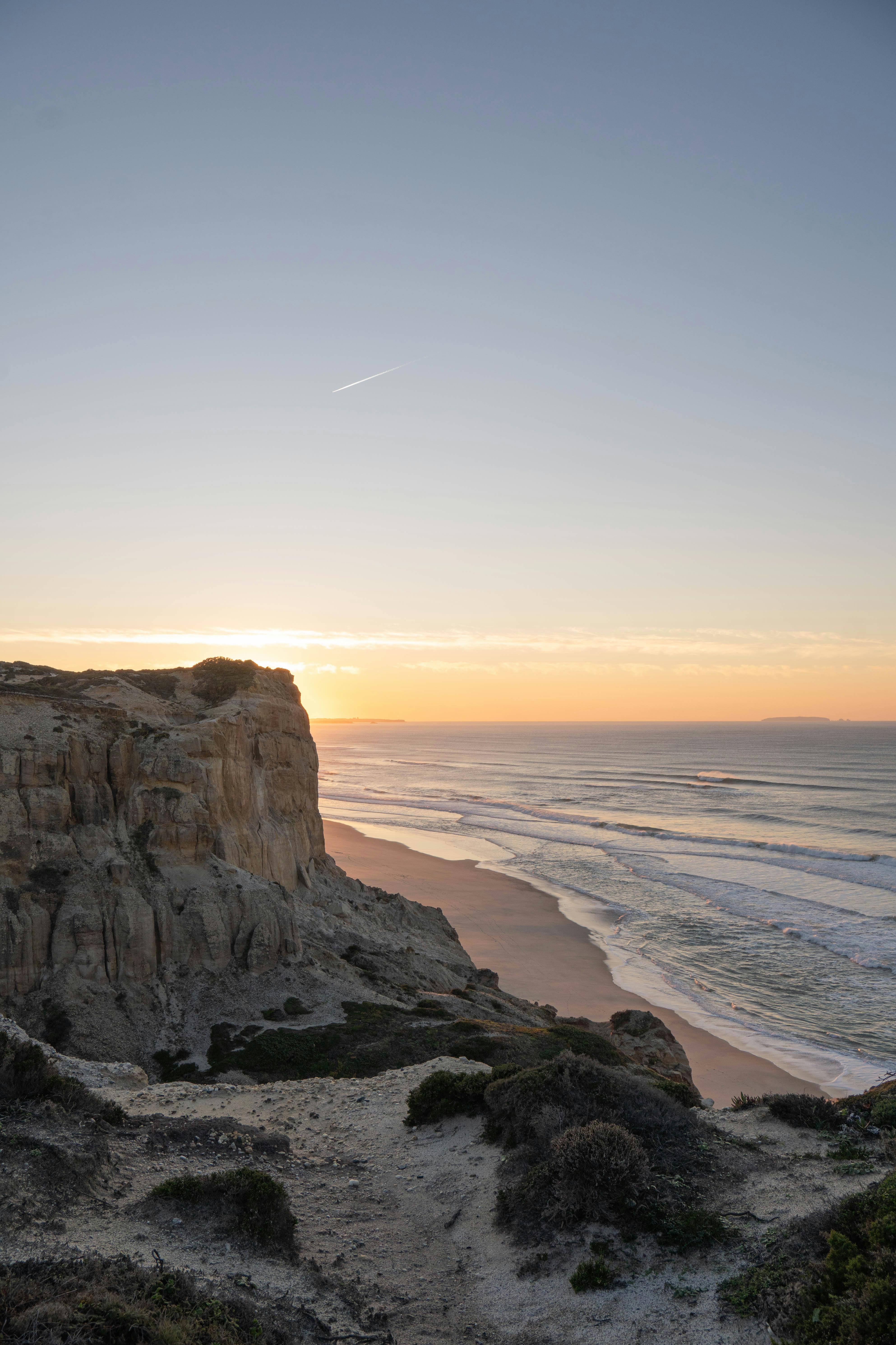Breathtaking sunset view of the iconic Nazaré cliffs and shoreline in Portugal. A beautiful natural landscape.