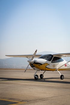 A small single-engine aircraft parked on a clear sunny airport runway.
