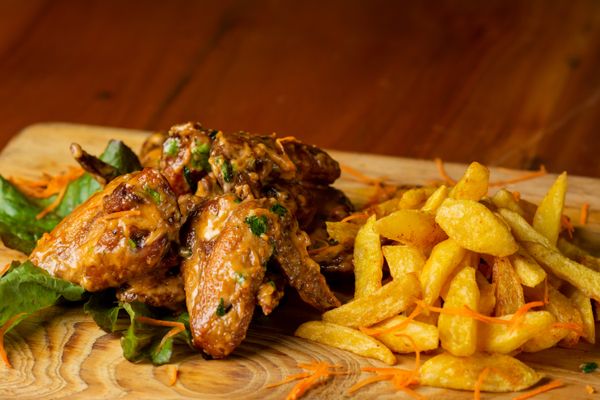 Glazed fried chicken wings served with thick-cut fries — photo by Lenon Mwamtobe on Pexels