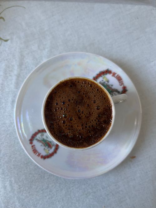 Free Top view of a foamy Turkish coffee served in a decorative porcelain cup and saucer. Stock Photo