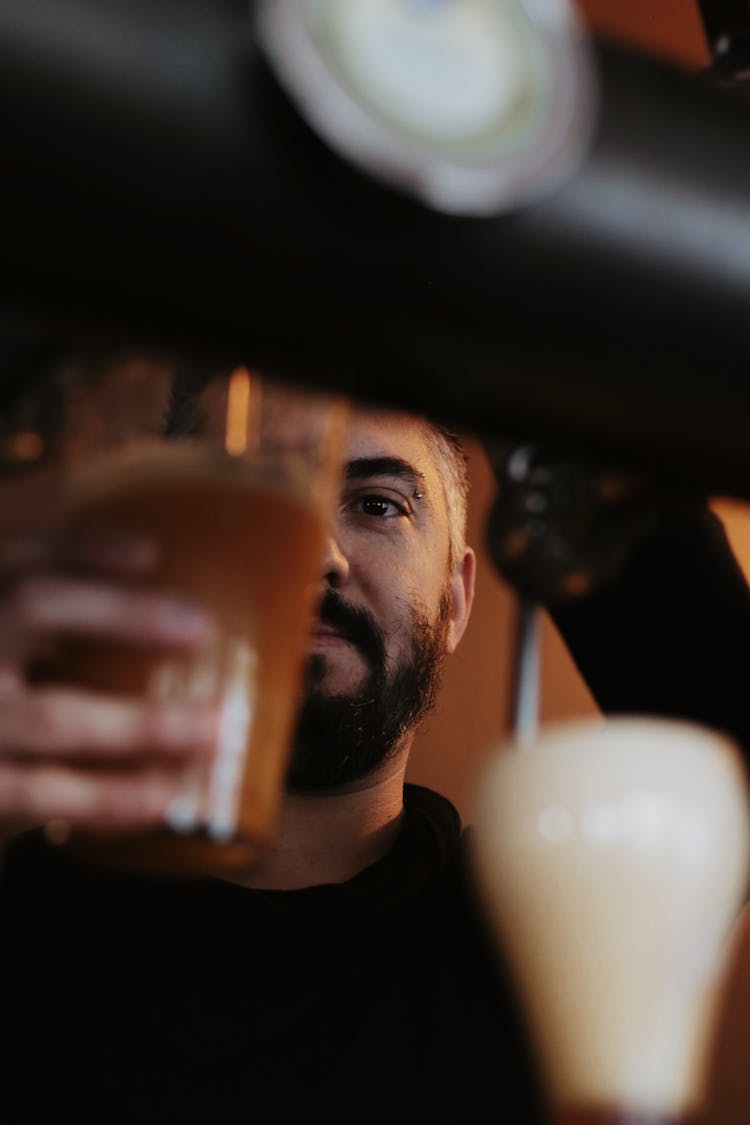 A Man Holding A Glass Of Beer