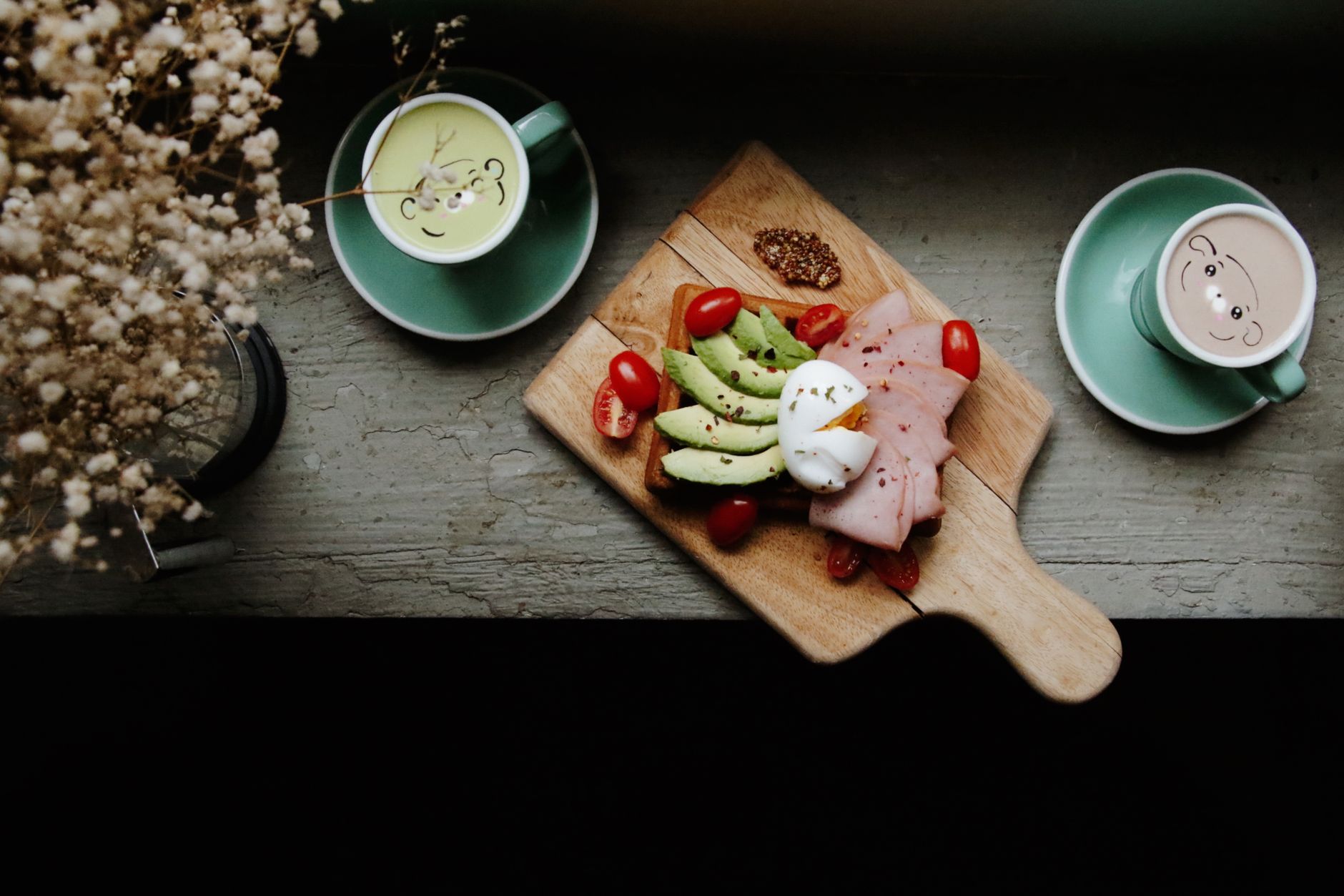 Delicious avocado toast with eggs and ham served with warm coffee in a cozy setting.