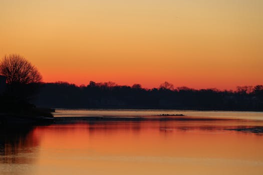 Serene sunrise over a peaceful lake with vibrant sky reflection.