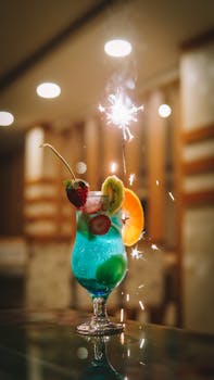 Colorful cocktail with fresh fruits and sparkler, perfect for celebrations.