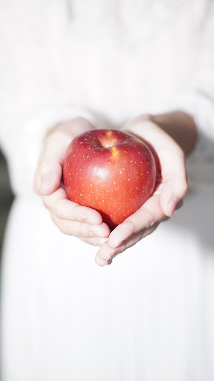 A Person Holding An Apple