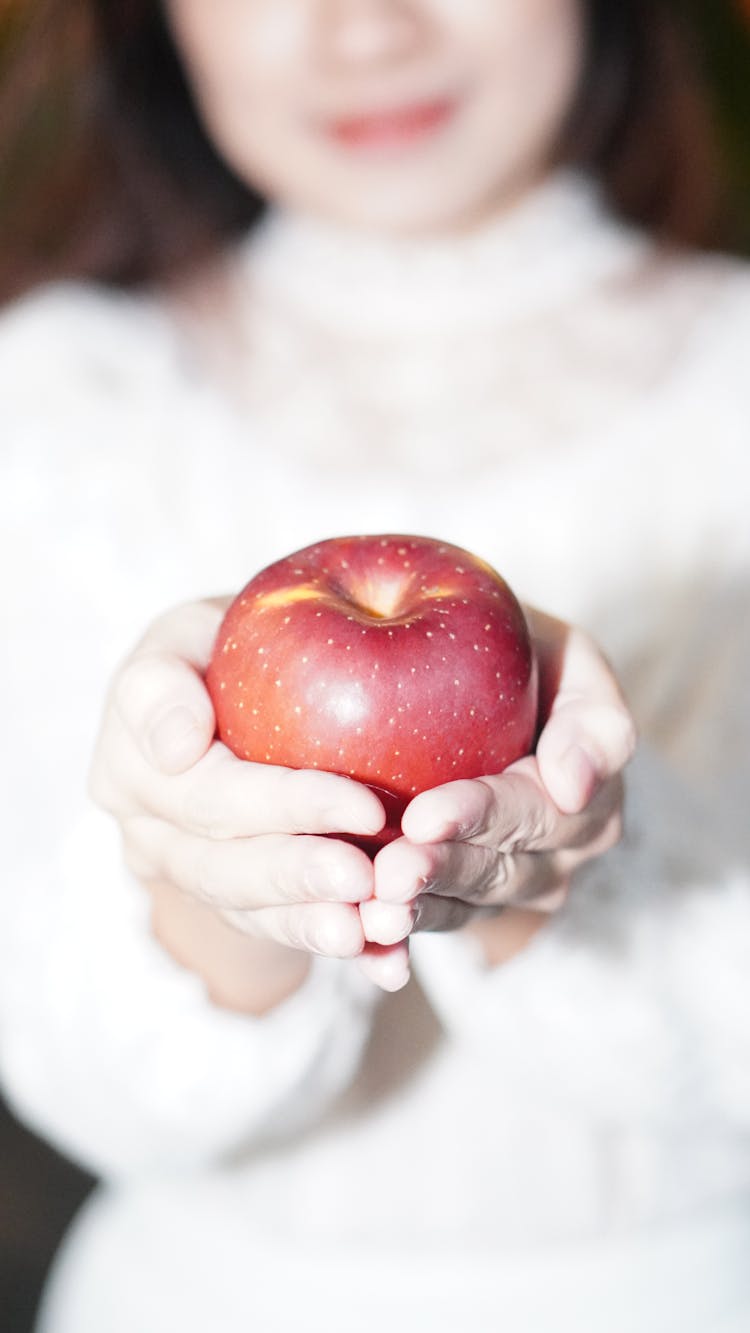 A Person Holding An Apple