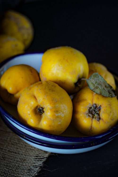 Free A rustic ceramic bowl filled with fresh yellow quinces, perfect for autumn decor or culinary inspiration. Stock Photo
