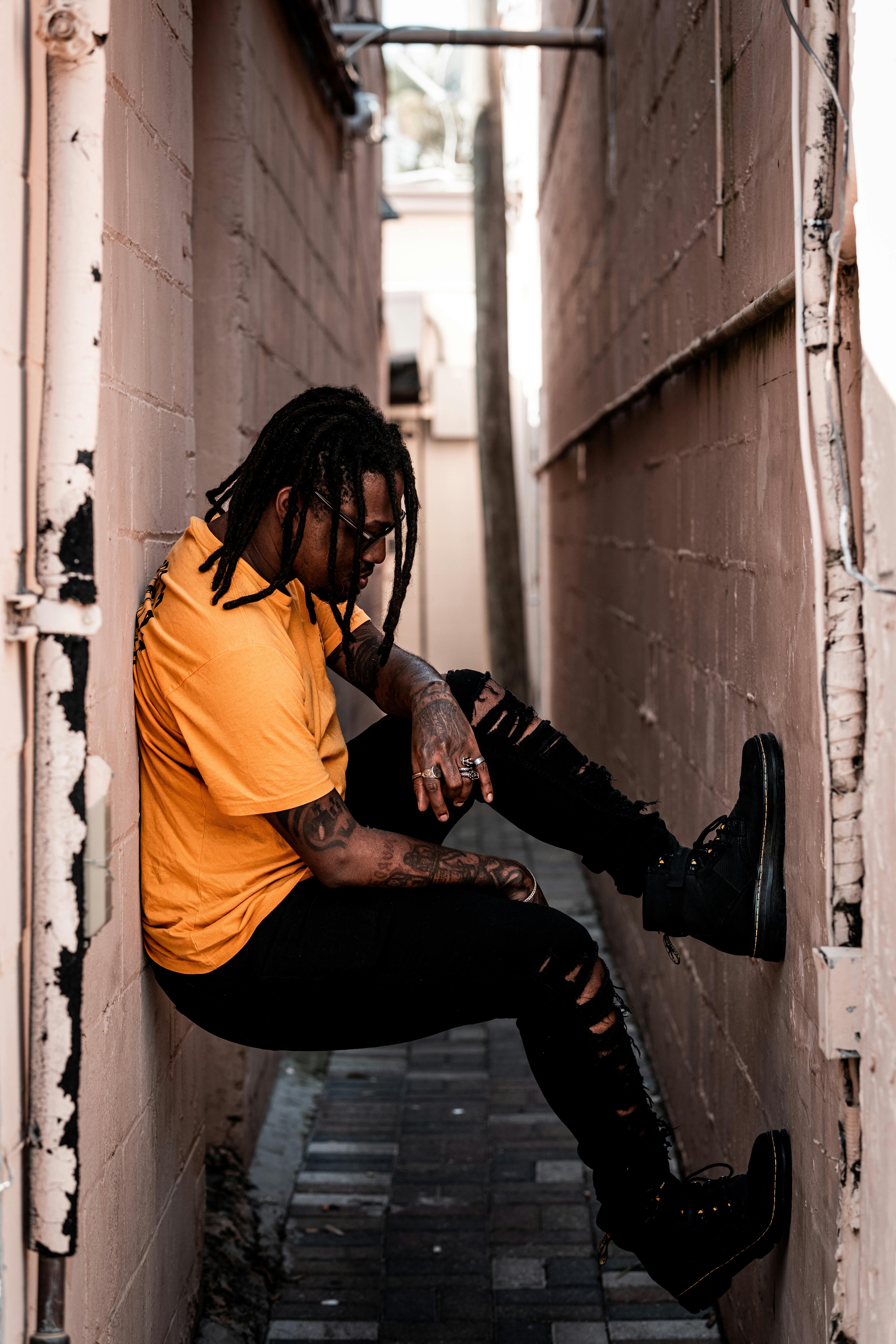 a man in a yellow shirt sitting on a wall