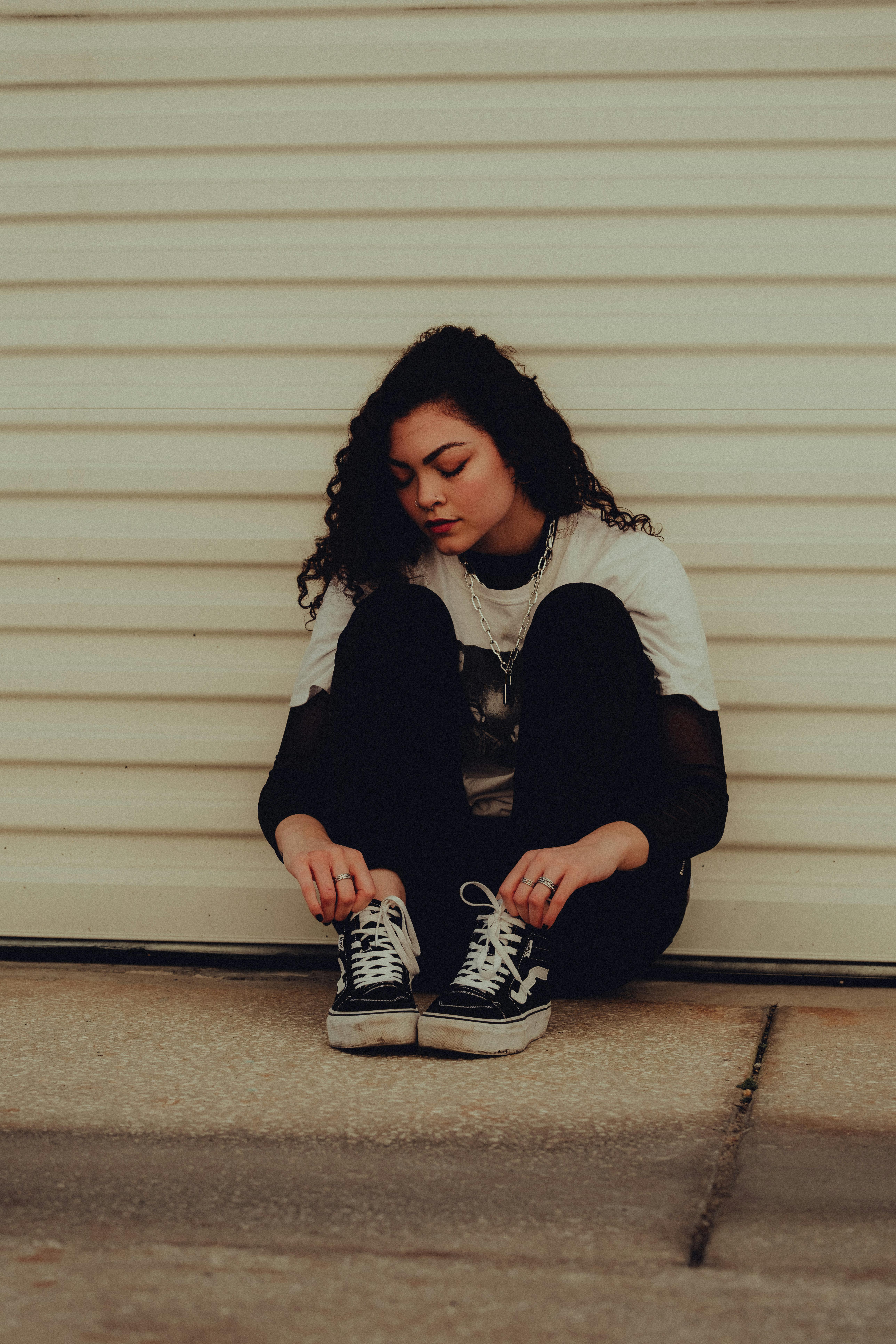 a woman sitting on the ground with her sneakers