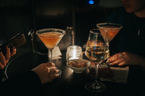 A Person Holding Wine Glass with Yellow Liquid